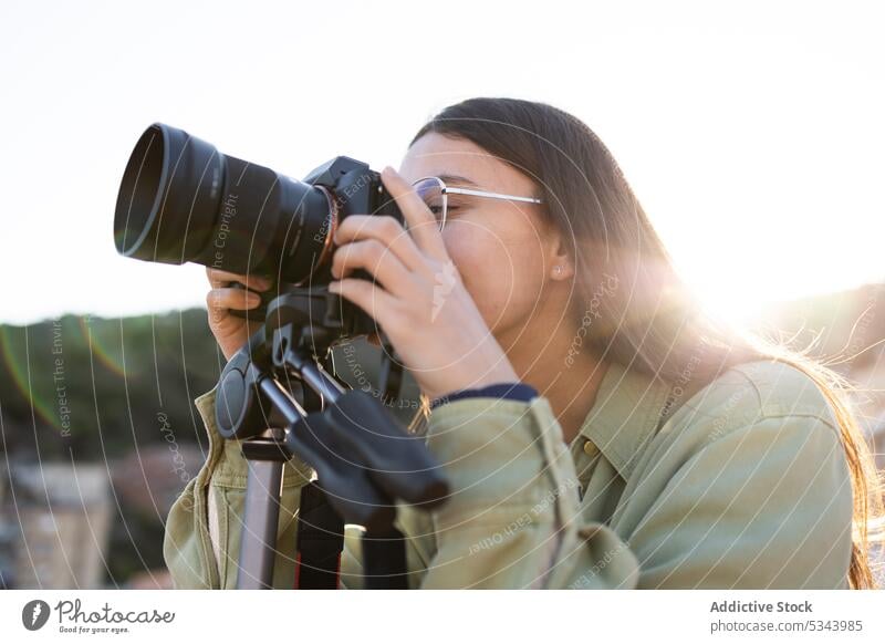 Junges Mädchen mit professioneller Kamera Fotograf Frau fotografieren Fotoapparat Hobby positiv Fotografie Brille Fotokamera Gerät Linse einfangen Moment