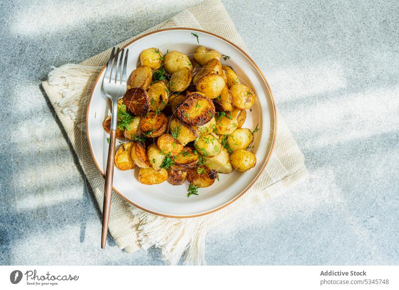 Frühlingskartoffel in Schale auf grauem Hintergrund Schalen & Schüsseln Besteck Diät Dill Abendessen Speise Teller bohren Lebensmittel frisch gebraten grün