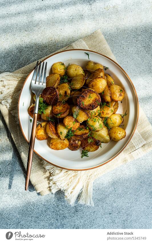 Frühlingskartoffel in Schale auf grauem Hintergrund Schalen & Schüsseln Besteck Diät Dill Abendessen Speise Teller bohren Lebensmittel frisch gebraten grün