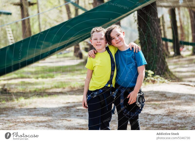 Fröhliche Kinder, die sich im Sommerwald umarmen Mädchen Junge Park Zusammensein Umarmung Glück Lächeln Freund Seil heiter Umarmen Partnerschaft Sonne positiv