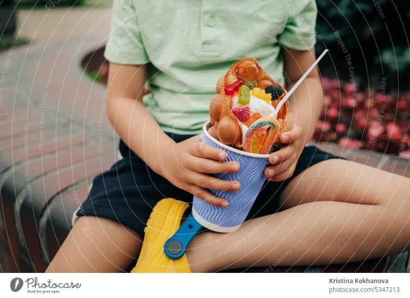 Kinder Hände mit leckeren süßen Dessert Waffeln und Süßigkeiten, Sahne, Marmelade Junge Schokolade Lebensmittel Snack Sommer geschmackvoll heiter Kindheit kalt