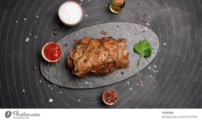 Gebackener Schweinekragen mit Gewürzen auf einem Holzbrett, leckeres und saftiges Fleisch gebacken Schweinehalsband hölzern Holzplatte gebraten