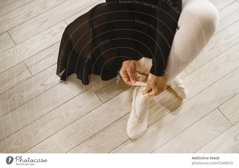 Anonyme Tänzerin beim Anziehen der Ballettschuhe in einem Studio Frau anonym spitze Ballerina vorbereiten Balletttänzer angezogen unkenntlich Atelier