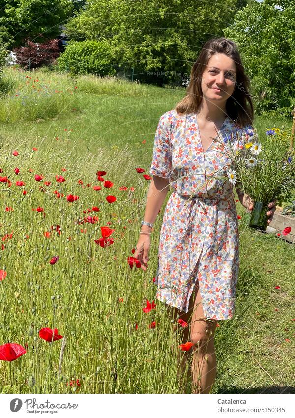 Frau im geblümtem Kleid und Blumenstrauß in der Hand duften Natur Flora Pflanze blühen Blüte Garten Gras Wiese Tag Tageslicht verblühen Person gehen Mohn