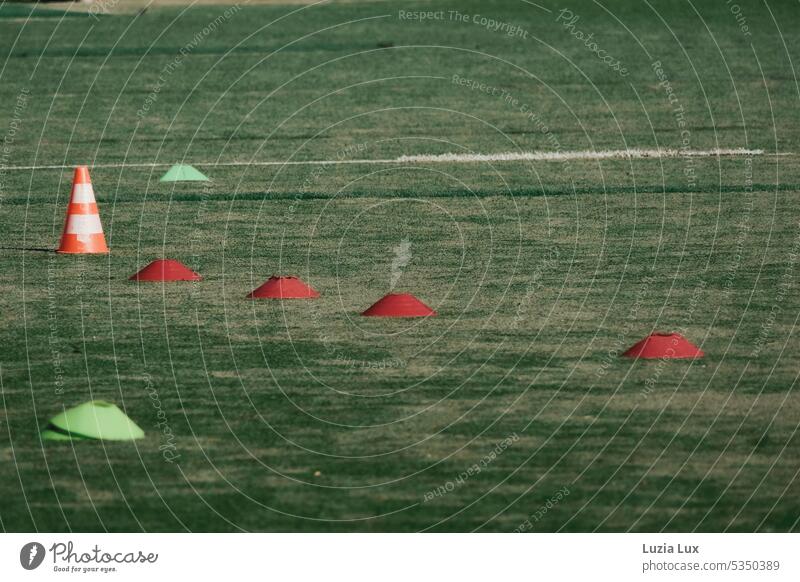 Auf dem Sportplatz bunte Markierungssteller, Schatten und Linien Bolzplatz Markierungshütchen farbig grün Rasen Fußballplatz Ballsport Spielfeld