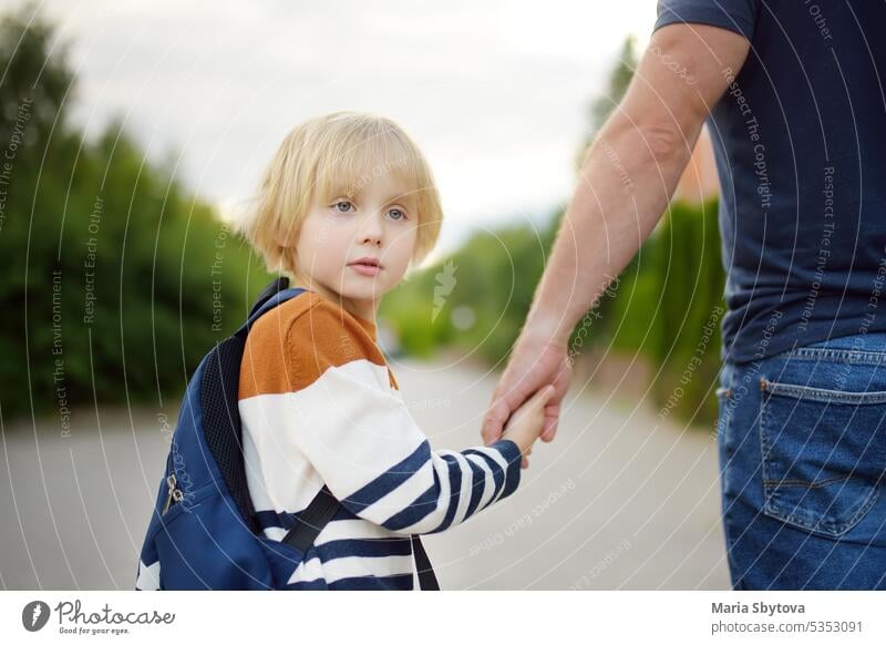 Kleiner Schuljunge geht mit seinem Vater nach den Sommerferien zur Schule. Ein Elternteil begleitet sein verängstigtes Kind. Kinder haben Ängste. Gute Bildung für Kinder. Zurück zur Schule