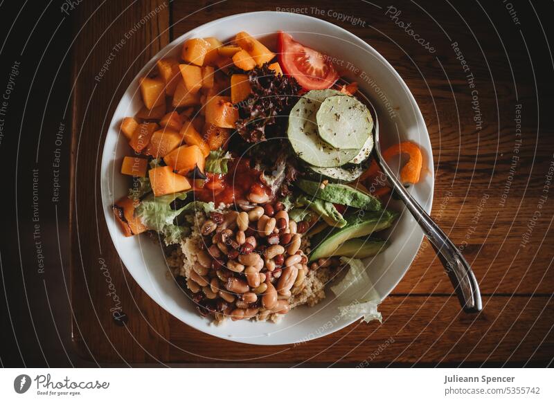 Schüssel mit gesundem, veganem, buntem Essen Buddha-Schale Tomate Tomaten beens Avocado rote Paprika Salatgurke Salatbeilage Squash gesunde Ernährung