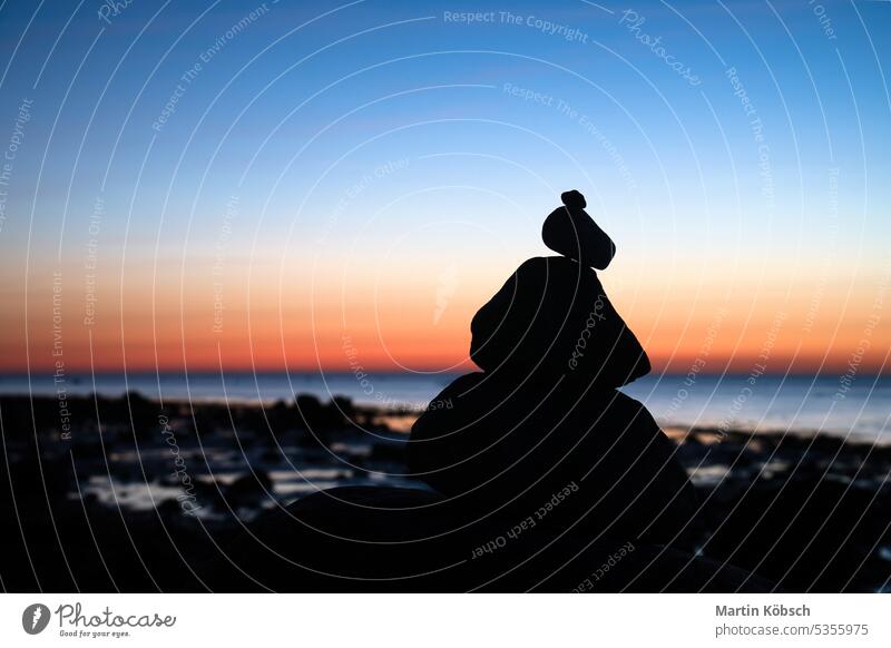 Steinpyramide an der Ostsee mit Blick auf das Meer bei Sonnenuntergang und blauer Stunde Pyramiden MEER baltisch Silhouette Steinhaufen Urlaub Himmel Küste