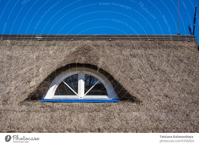 Fragment eines alten Stroh- oder Schilfdaches mit einer halbrunden Dachgaube Bruchstück Schilfrohr Dachfenster Architektur Strohdach traditionell Haus