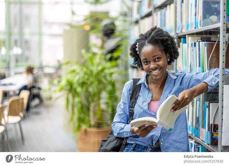 Schwarze Studentin liest ein Buch in einer Bibliothek echte Menschen Teenager Campus positiv Prüfung Wissen selbstbewusst schulisch Erwachsener Lifestyle