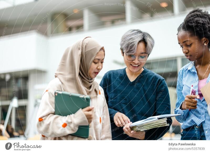 Gruppe multiethnischer Studenten bei einer Diskussion in einer Bibliothek echte Menschen Teenager Campus positiv Prüfung Wissen selbstbewusst schulisch