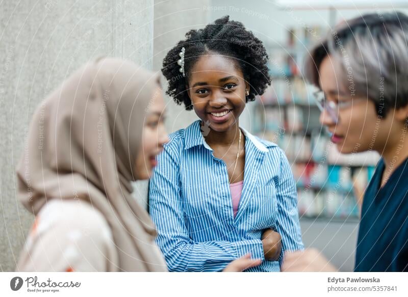 Gruppe multiethnischer Studenten bei einer Diskussion in einer Bibliothek echte Menschen Teenager Campus positiv Prüfung Wissen selbstbewusst schulisch