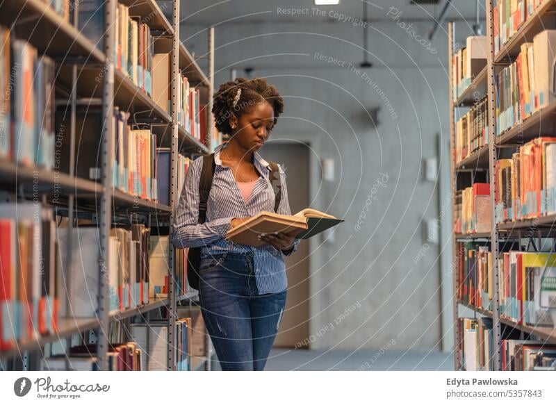 Schwarze Studentin liest ein Buch in einer Bibliothek echte Menschen Teenager Campus positiv Prüfung Wissen selbstbewusst schulisch Erwachsener Lifestyle