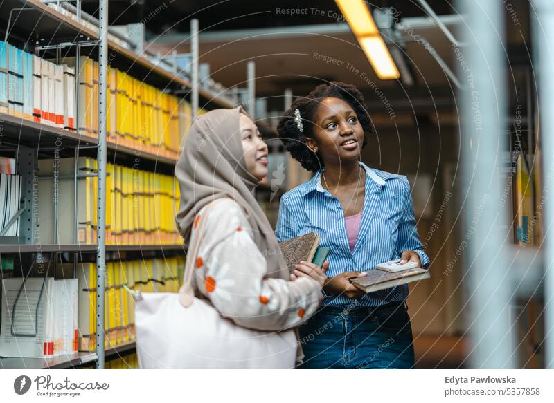 Zusammenstehende Studentinnen in der Universitätsbibliothek echte Menschen Teenager Campus positiv Prüfung Wissen selbstbewusst schulisch Erwachsener Lifestyle