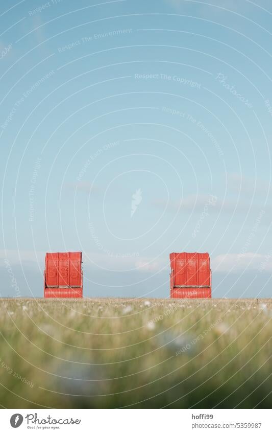 zwei Rote Strandkörbe auf einer Wiese am Meer rot Strandkorb Wolkenloser Himmel Idylle Einsamkeit Romantik Küste Rasen Nordsee Zufriedenheit Schönes Wetter