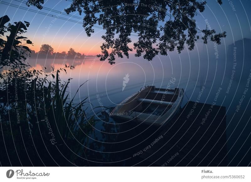 Ruderboot in der Dämmerung See Nebel Wasser Natur ruhig Himmel Baum Morgen Landschaft Herbst Wolken Außenaufnahme Seeufer Morgendämmerung Umwelt