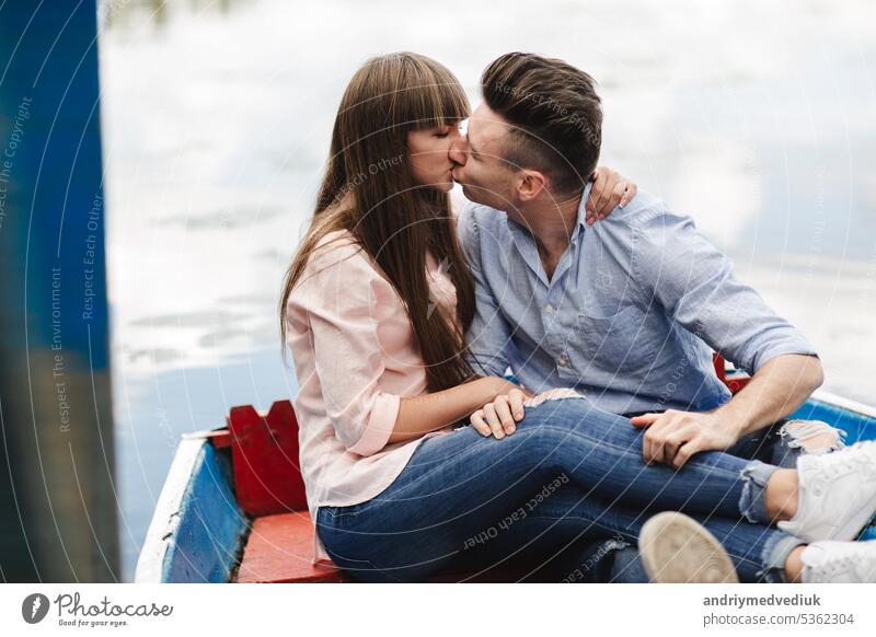 Ein Paar, das in einem blauen Boot auf einem See fährt. romantisch. emotionales Paar. lustig und verliebt jung Wasser Glück Sommer Romantik Fluss Urlaub Frau