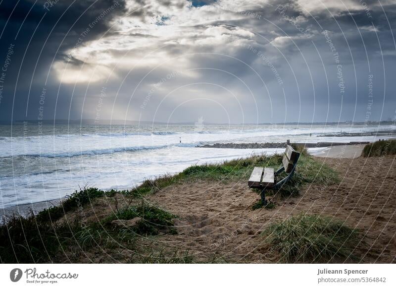 Bank mit Blick auf das Meer bei stürmischem Wetter Strand atmosphärisch Landschaft Wolken Außenaufnahme Himmel Küste Farbfoto Menschenleer Wellen Natur Wasser