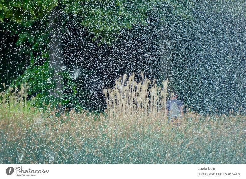 Sommer im Park.... im Grün hinter den Tropfen eines Springbrunnens ist ein Spaziergänger zu erahnen grün sommerlich urban Stadt Wasser Wassertropfen Brunnen