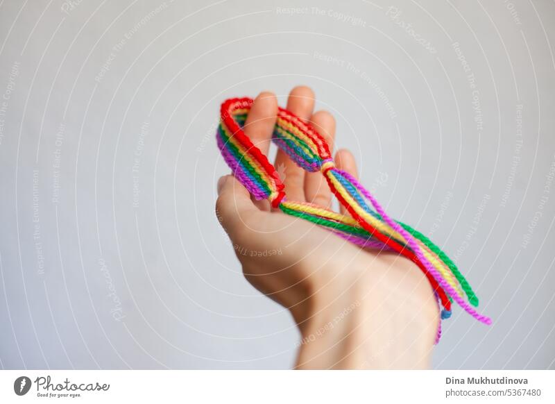 Hand hält Regenbogen häkeln handgemachte Armband. Feiern Stolz Monat mit Symbol Farben der lgbt abstrakt Kunst Hintergrund Business farbenfroh Konzept gemütlich