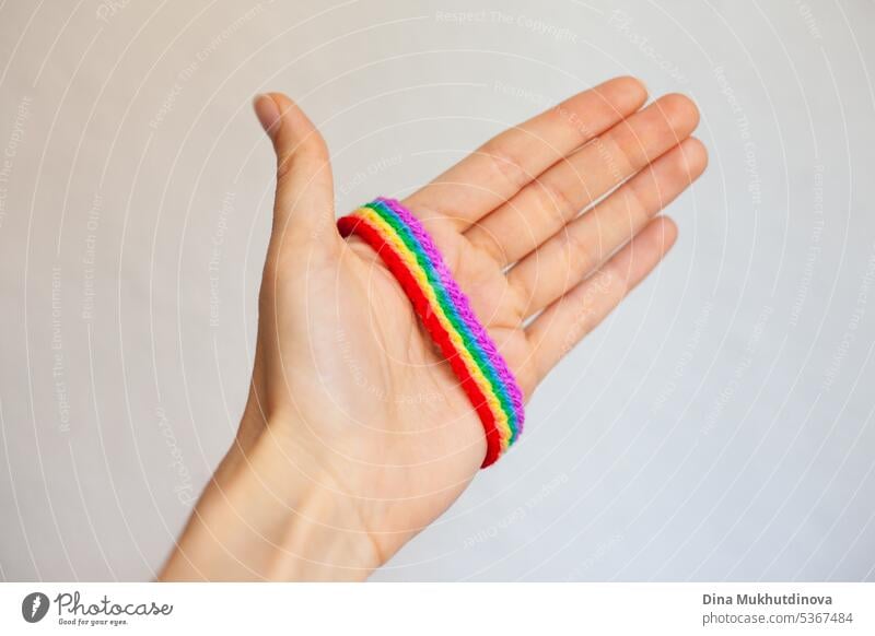 Hand hält Regenbogen häkeln handgemachte Armband. Feiern Stolz Monat mit Symbol Farben der lgbt abstrakt Kunst Hintergrund Business farbenfroh Konzept gemütlich