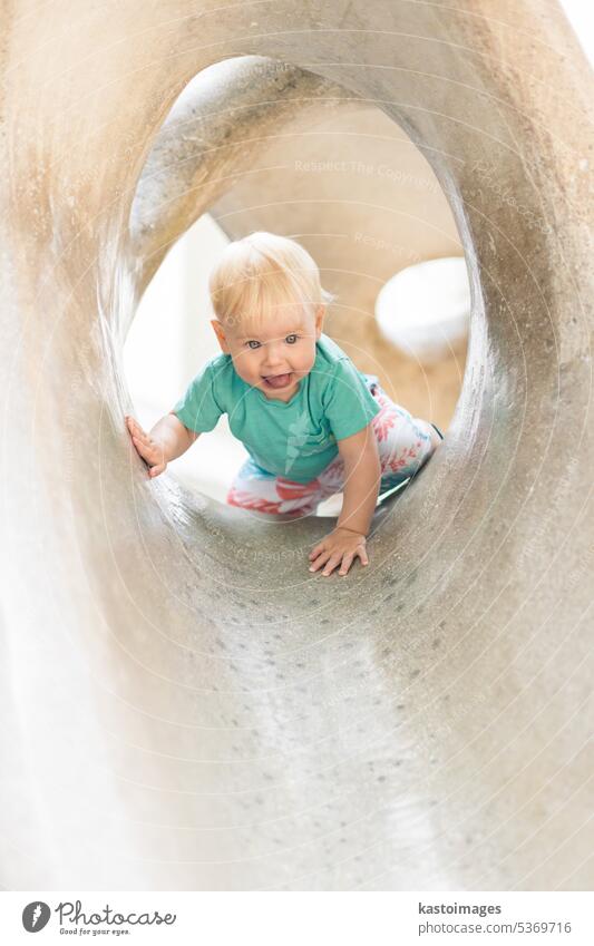 Kind spielt auf Spielplatz im Freien. Kleinkind spielt auf Schule oder Kindergarten Hof. Aktives Kind auf Stein gemeißelter Rutsche. Gesunde Sommeraktivität für Kinder. Kleiner Junge klettert im Freien.