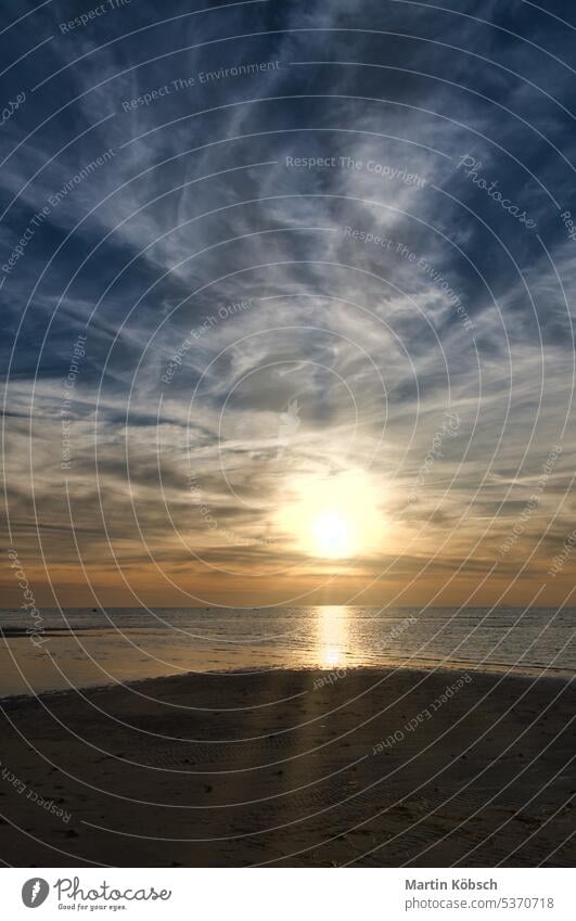 Sonnenuntergang, Blick über den Sandstrand auf das beleuchtete Meer. Leichte Wellen. Ostsee Sonnenstrahlen Sonnenschein Reflexion & Spiegelung Glitter gelb blau