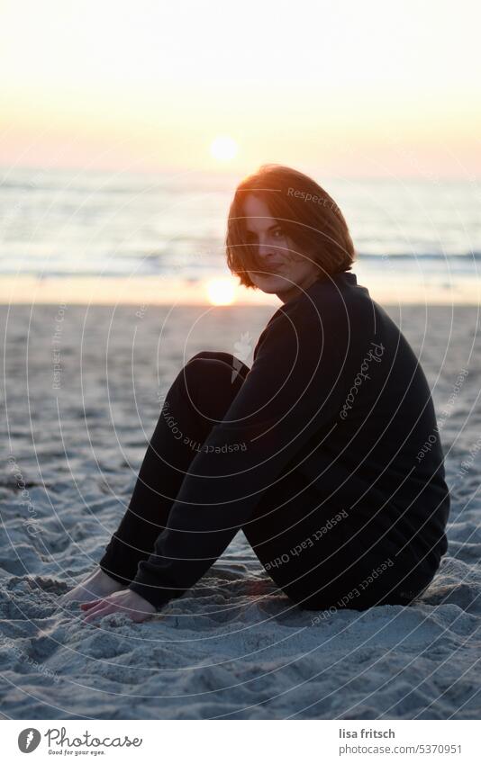 SONNENUNTERGANG AM MEER.. Frau 30-35 Jahre brünett Wind in den Haaren kurzhaarig Haare im Gesicht sitzend Zufriedenheit glücklich Freude Erwachsene Farbfoto