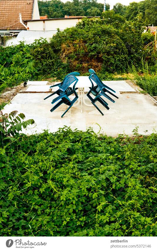 Ein Tisch, vier Stühle ast baum erholung familie ferien garten gartenmöbel hecke kleingarten kleingartenkolonie menschenleer monoblock nachbarschaft natur