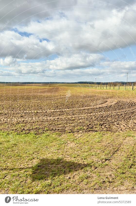 Acker mit Schatten Vehrkehrsschild Horizont ZAun Rasen Grün Reifenspuren Erde Frühling NAchmittag Wolken LAndschaft Spazierengehen Himmel LAndwirtschaft Feld