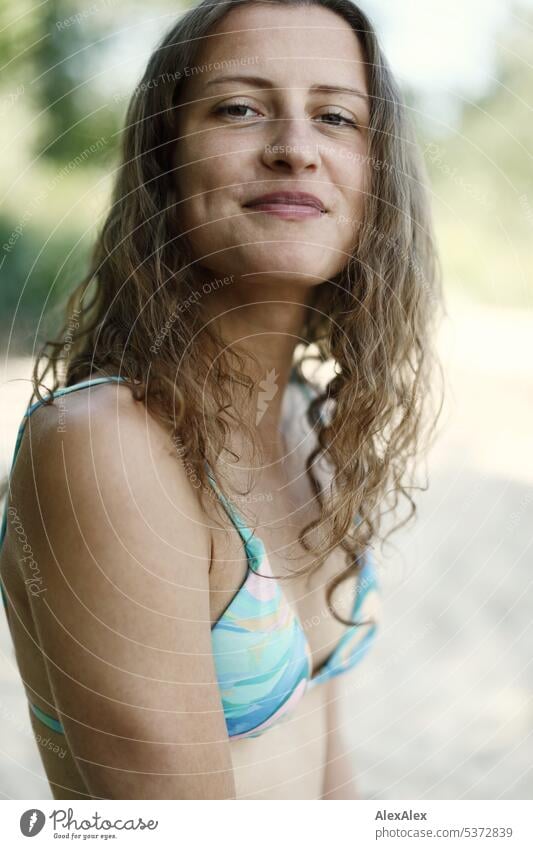 direktes Portrait einer jungen, schönen, brünetten, lächelnden Frau im Bikini am Strand warm sommerlich schönes wetter Sommer Pflanzen Nähe Tag Ruhe