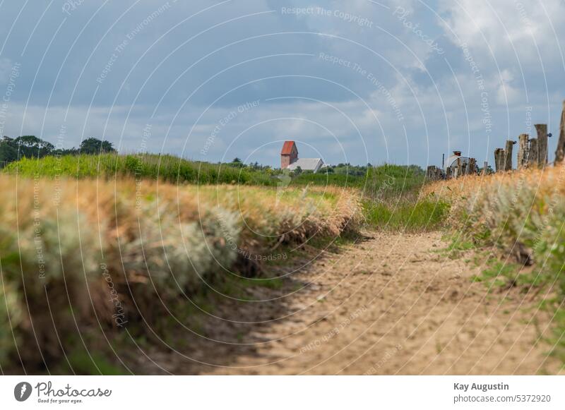 Am Wassergraben mit blick auf die St.Serverin Kirche ackergraben am priel wattenmeer salzwiesen wasserläufe im watt kirche st.serverin gezeiten vertiefung