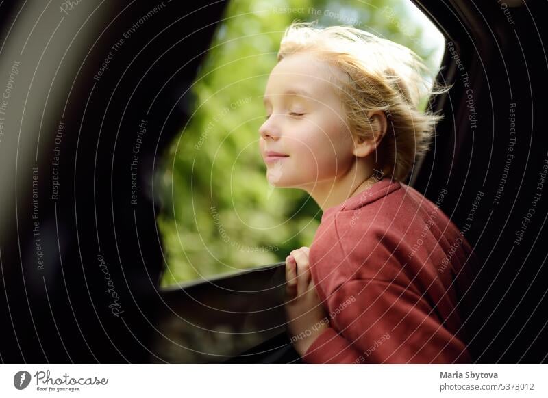 Cute preteen Junge atmet die Luft der Freiheit aus dem Autofenster während der Familie Road Trip und genießen Sie die angenehme Erwartung der glücklichen Urlaub. Joyful Kind reisen mit Eltern