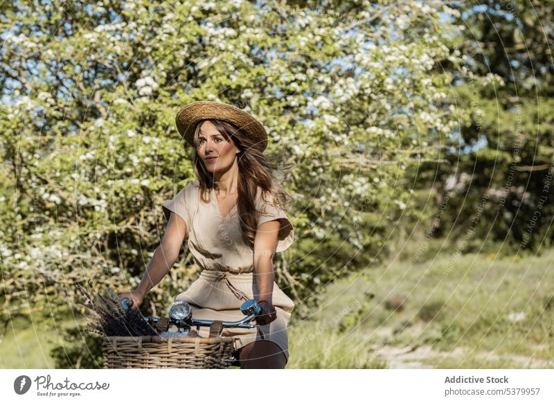 Frau fährt Fahrrad auf dem Lande Landschaft Mitfahrgelegenheit Natur Sommerzeit sorgenfrei Spaß Glück Strohhut gesamt Stil ländlich lange Haare natürlich