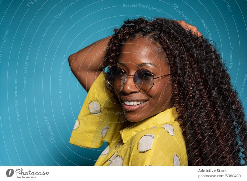 Elegante lächelnde Frau mit lockigem Haar schaut in die Kamera Lachen Glück krause Haare heiter Humor Spaß genießen froh Lächeln Freude schwarz Afroamerikaner