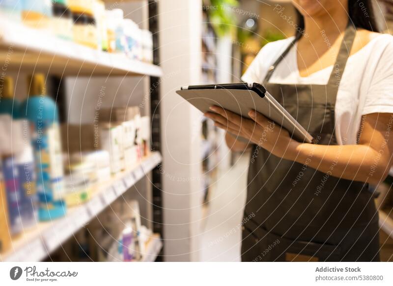 Anonyme Frau mit Tablet im Geschäft anonym Werkstatt Verkäufer Tablette Ware Arbeit Laden Kleinunternehmen Regal asiatisch jung ethnisch verkaufen Glück