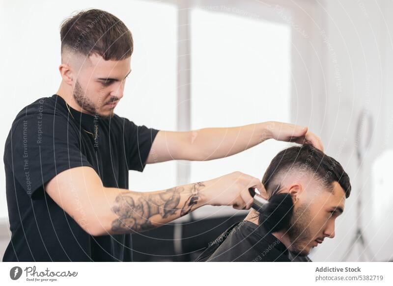 Junge Friseurin beendet Haarschnitt im Friseursalon Barbershop Vollbart bärtig Bartiger Mann Schönheit Pflege Klient Ausschnitt Frisur Typ Behaarung modern