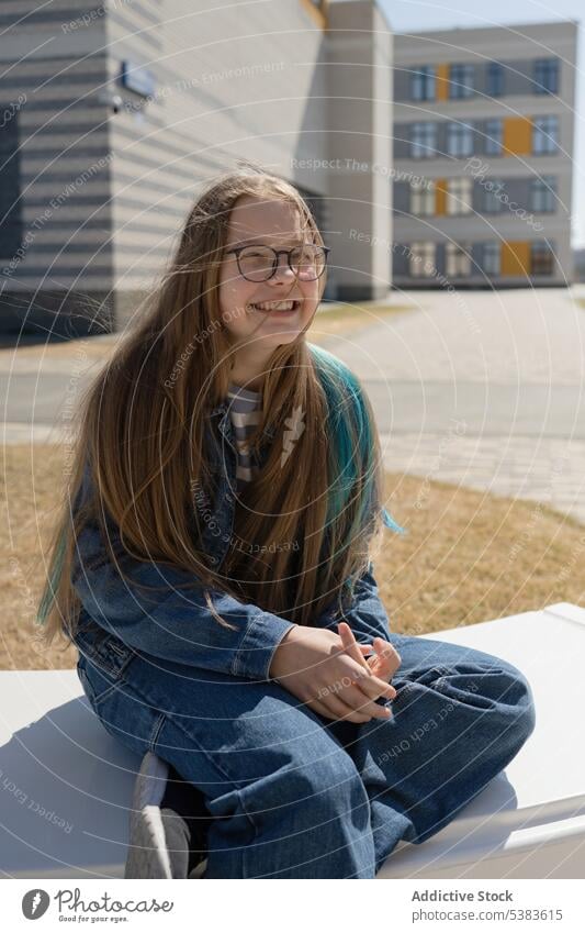 Teenager-Mädchen ruht sich auf einer weißen Bank in der Stadt aus Großstadt Gebäude sich[Akk] entspannen Freizeit sonnig sitzen trendy Sommer Outfit urban jung