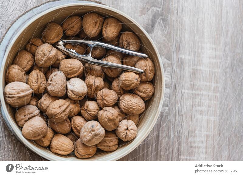 Keramikschüssel mit getrockneten Walnüssen und Zange, Ansicht von oben Walnussholz Riss Schalen & Schüsseln gesunde Ernährung organisch Nut Gesundheit ganz