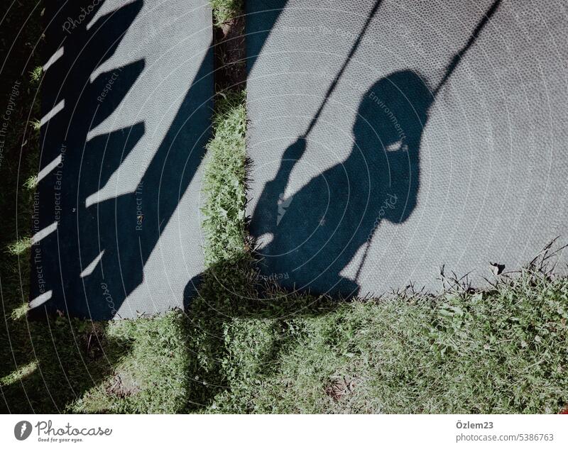 Schatten eines schaukelnden Kindes Schaukel Spielplatz Spielen Kindheit Freude Außenaufnahme Bewegung Lebensfreude Fröhlichkeit Glück Sommer Kinderspiel