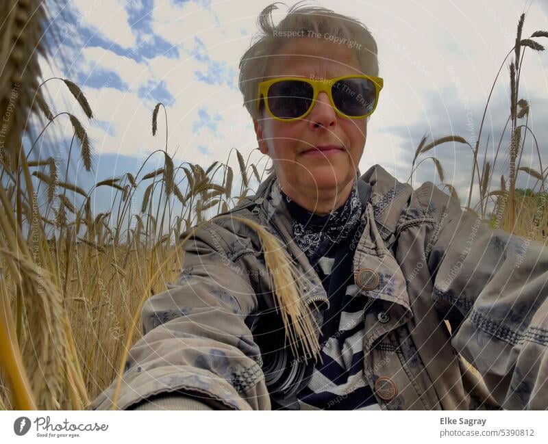 Blonde Frau mit gelber Sonnenbrille im Kornfeld Porträt feminin Mensch Haare & Frisuren schön Gesicht Blick 18-30 Jahre Frauengesicht Frauenaugen natürlich