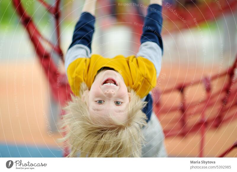 ?ute keck Vorschüler Junge Spaß auf Spielplatz im Freien. Frühling/Sommer/Herbst aktiv Sport Freizeit für Kinder. Outdoor-Aktivitäten für Kinder. Aufstieg