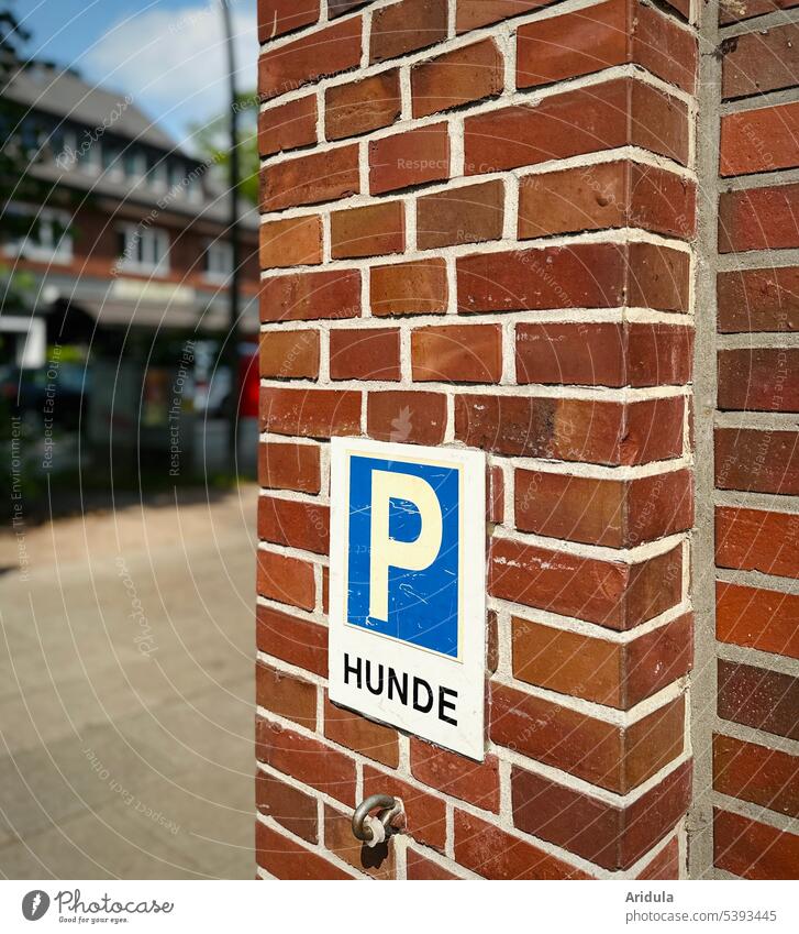 Hunde-Parkplatz anleinen festbinden parken Einzelhandel Einkauf Haustier einkaufen Supermarkt Kunde Laden Schilder & Markierungen Parkschild Hauswand Backstein