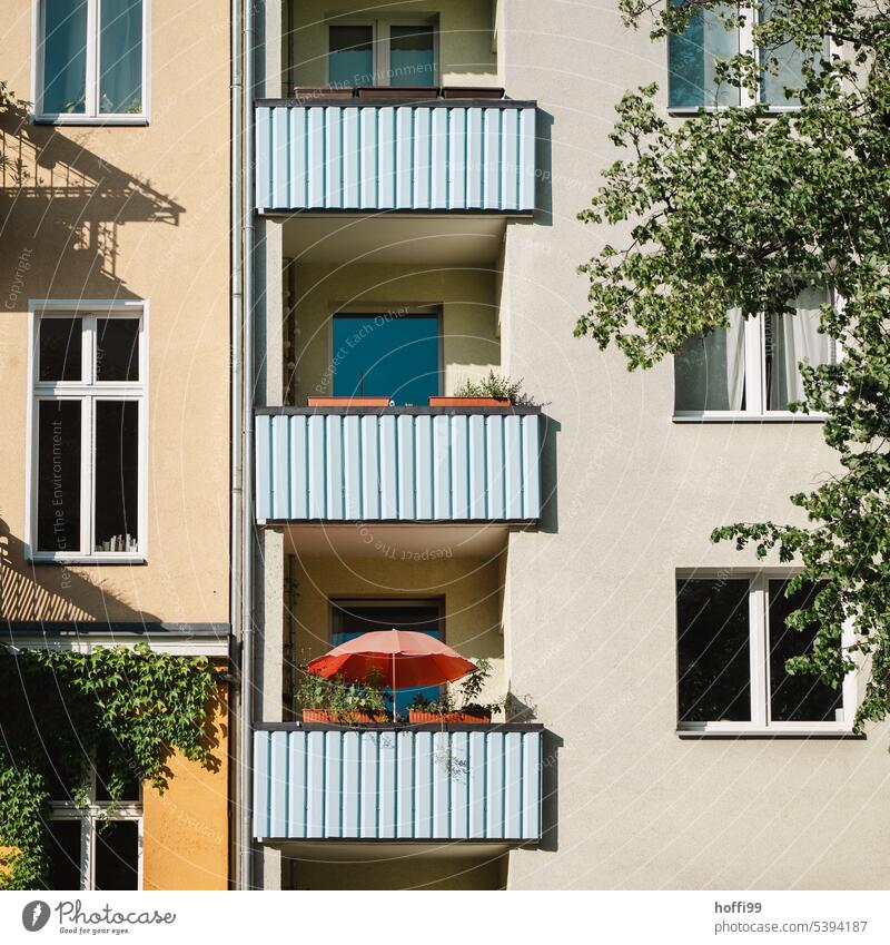 städtisches Balkonen Idyll mit rotem Sonnenschirm Roter Sonnenschirm Sommer Hitze Schatten Wie Wohnhaus Stadt Sonnenlicht Schönes Wetter Gebäude Haus