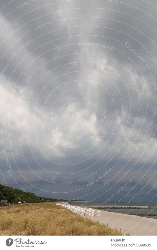 aufziehendes Gewitter an der Ostsee Gewitterwolken bedrohlich Strand Zingst Strandkörbe Dünengras Seebrücke Himmel düster Wetter schlechtes Wetter Sturm dunkel