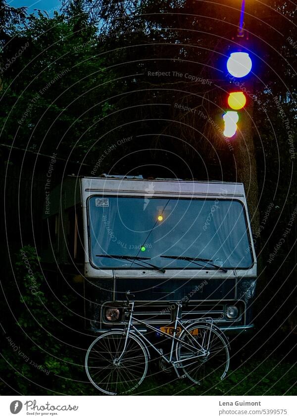 Camper mit Fahrrad und Lichterkette Abend Beleuchtung dunkel leuchten Baum Campen Wohnmobil Campingplatz Urlaub Abenteuer Außenaufnahme Farbfoto Freiheit Sommer