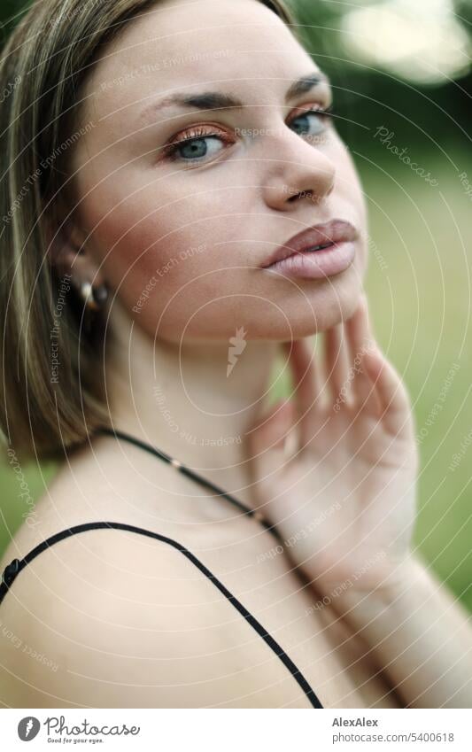 Portrait einer jungen, geschminkten Frau, die gehobenem Kopf zur Seite schaut junge Frau Frauengesicht Schminke Make-up schön schlank Stimmung Nahaufnahme