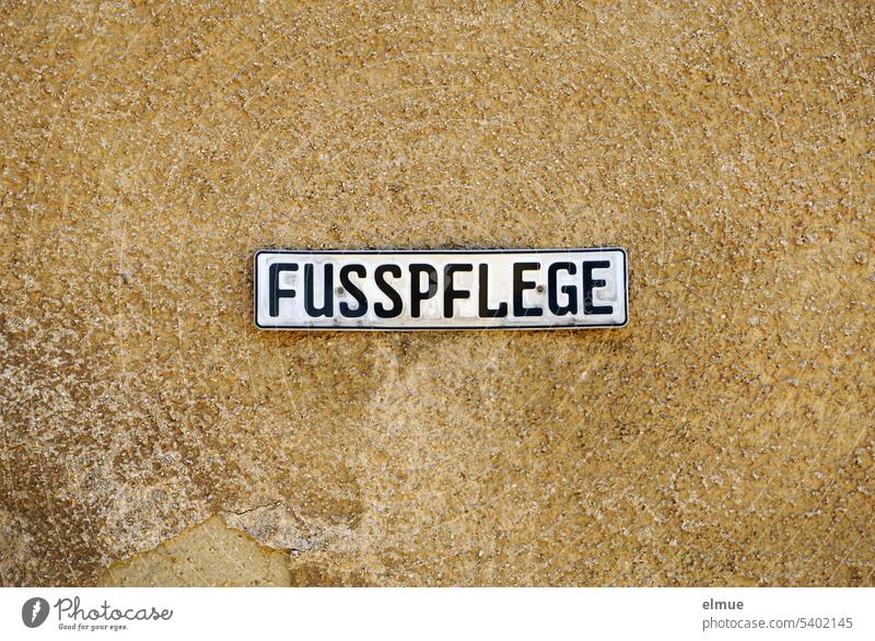 Schild mit der Aufschrift FUSSPFLEGE an einer verputzten Wand / Parkplatz Fußpflege Fusspflege Pediküre Hinweisschild parken Blog freihalten Wandputz