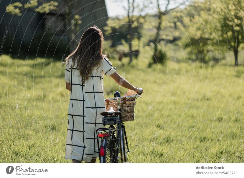 Anonyme junge Frau mit Fahrrad auf dem Lande Feld Landschaft Natur lässig Aktivität Lifestyle Gras Spaziergang frisch ländlich Sommerzeit sorgenfrei aktiv