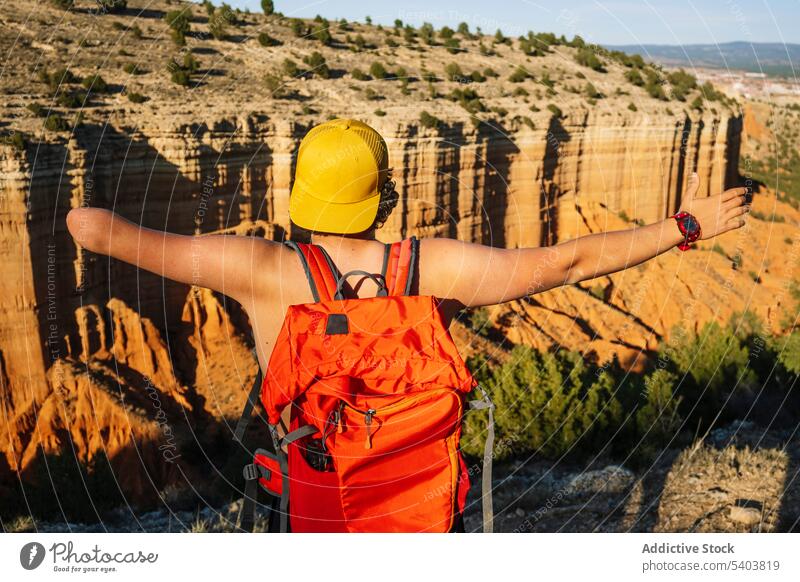 Unbekannter Reisender mit Rucksack über majestätischen Bergen Mann Amputierte ohne Hemd Freiheit Schlucht Klippe Schatten männlich Urlaub lässig rojo teruel